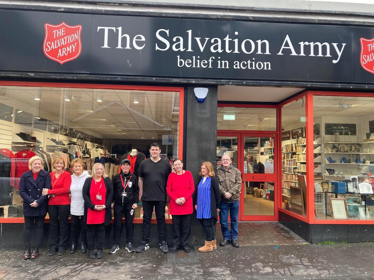 A group of volunteers standing outside a Salvation Army charity shop