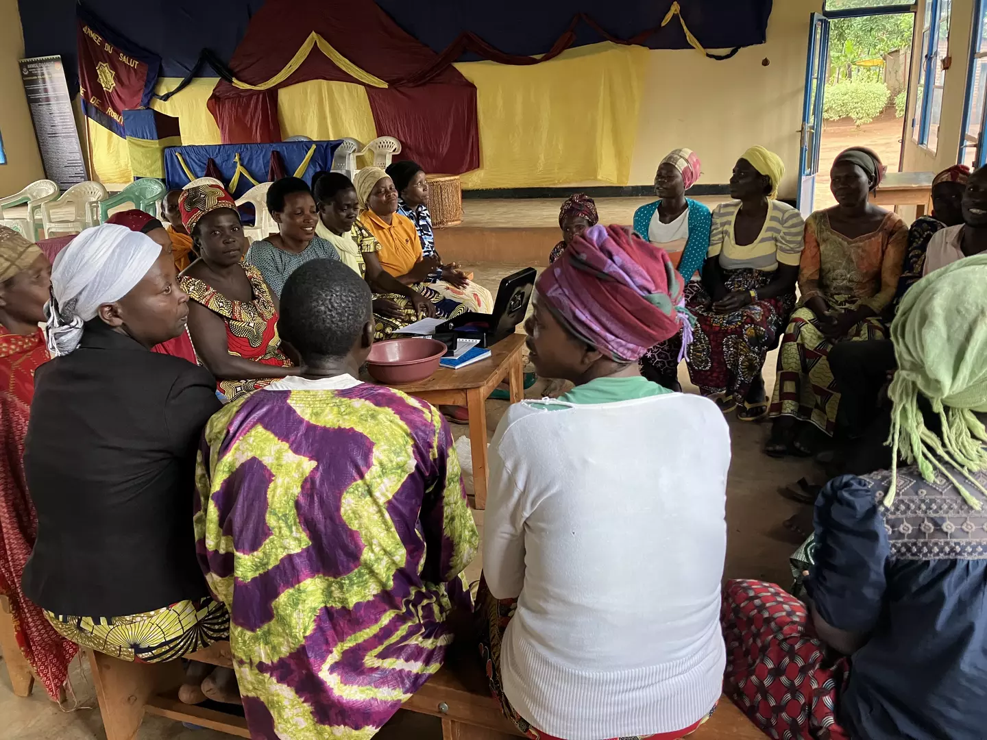 17 Rwandan women sat in circle for savings group meeting 