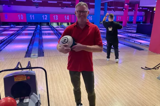 Peter holds up a bowling ball 